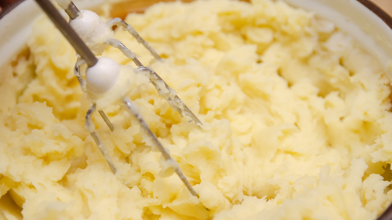 Mashed potatoes being whipped with electric mixer