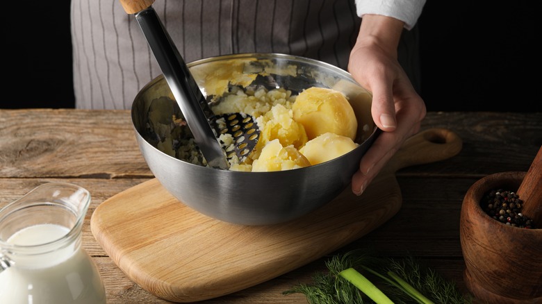 Person mashing potatoes by hand