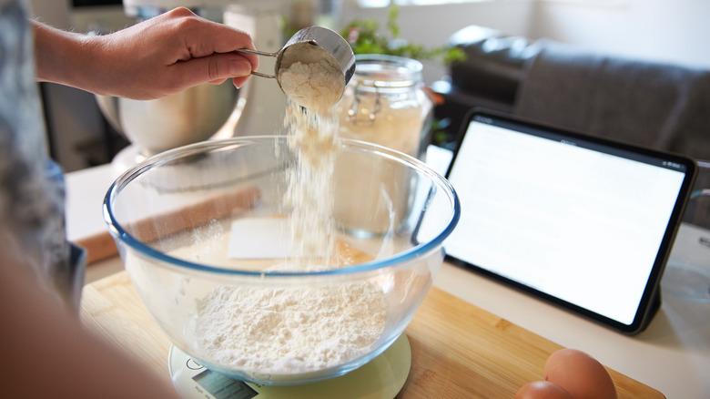 Person measuring flour into bowl