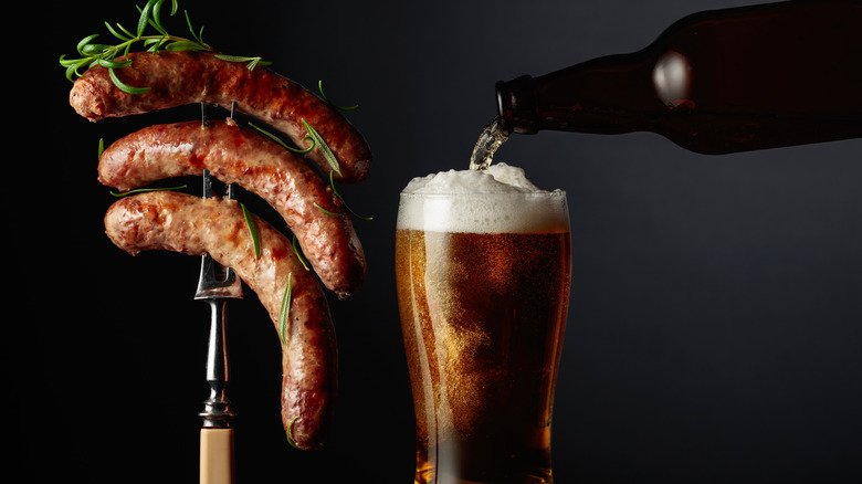 Brats on a grilling fork and beer