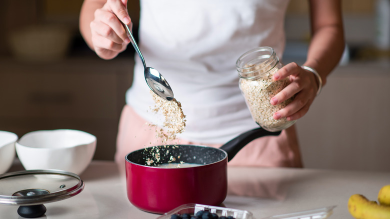 Person putting oats into milk