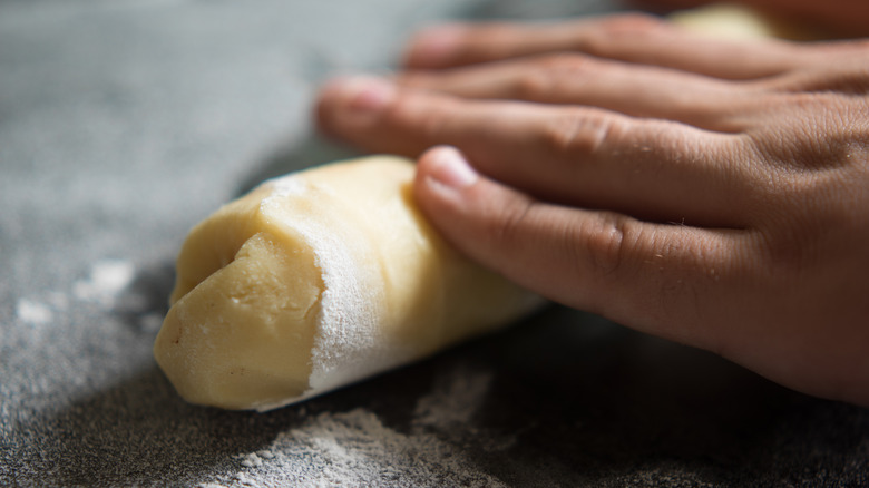 rolling cookie dough into cylinder