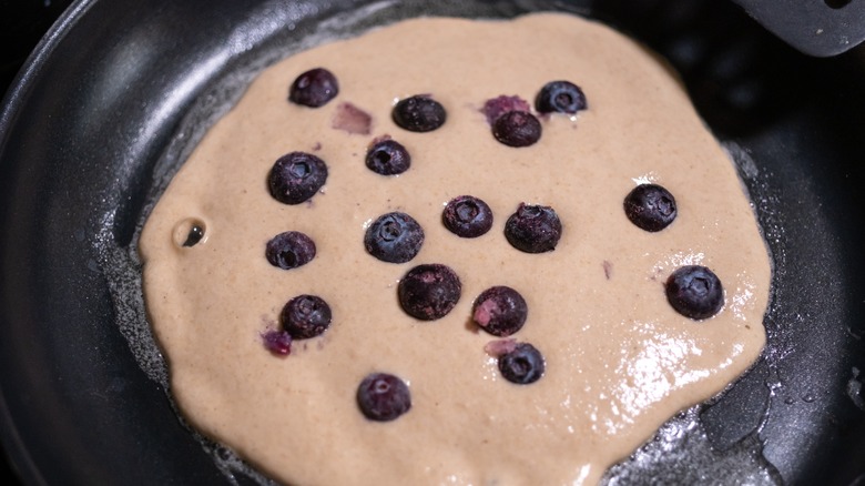 Blueberries in pancake batter cooking