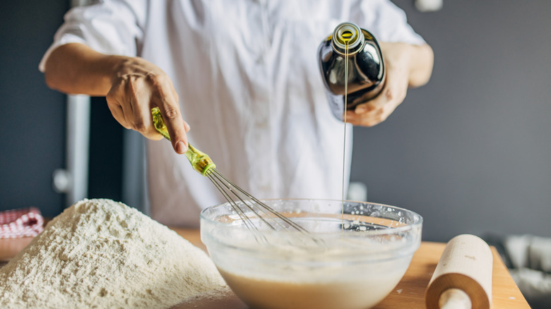 Pouring oil into bowl with flour