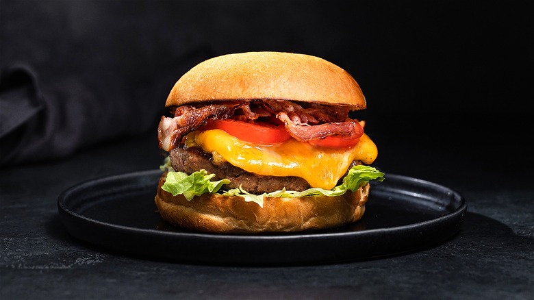 Bacon cheeseburger on black plate 