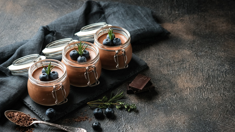 Small pots of chocolate mousse with blueberries and rosemary