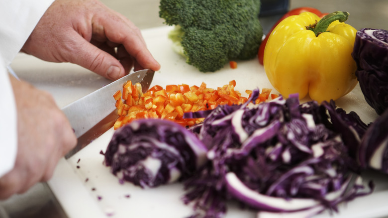 chef chopping vegetables on cutting board