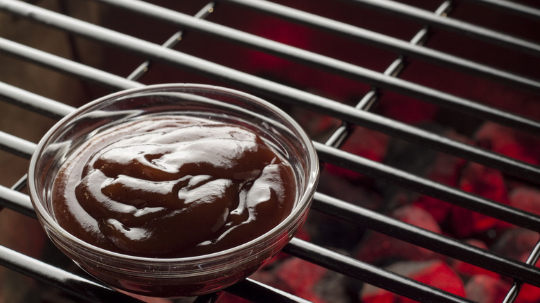 ramekin of barbecue sauce on grill