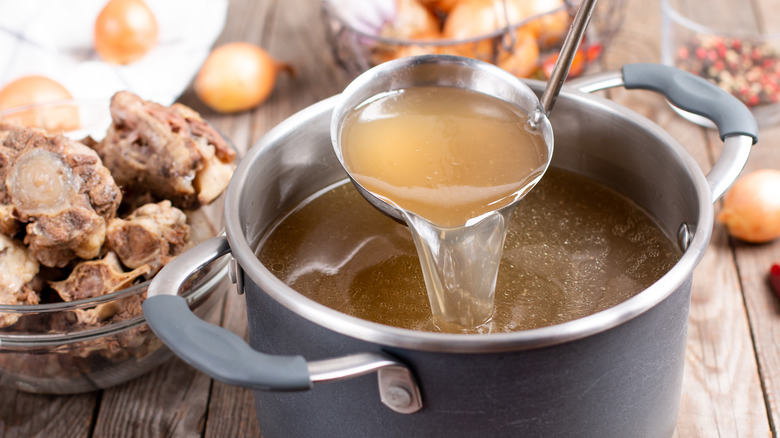 Stock pot with bone broth and ladle