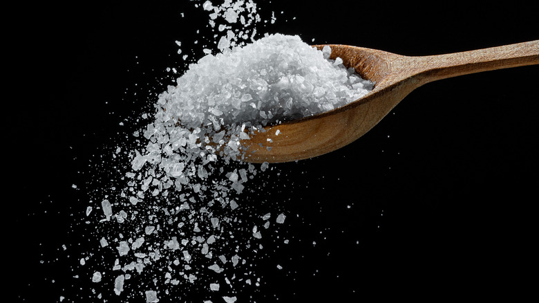 kosher salt grains falling with spoon