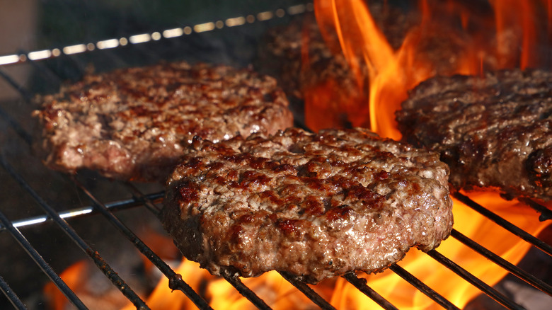 Grilling burgers over fire