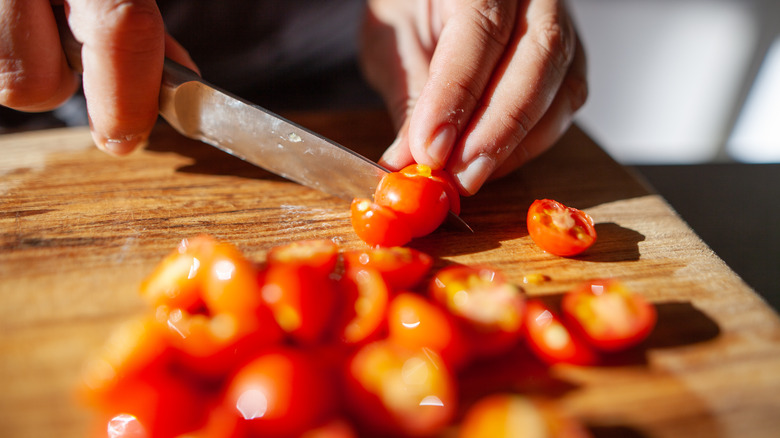 slicing cherry tomatoes on board