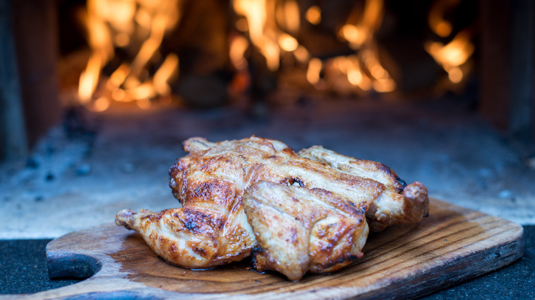 chicken coming out of wood-fired pizza oven