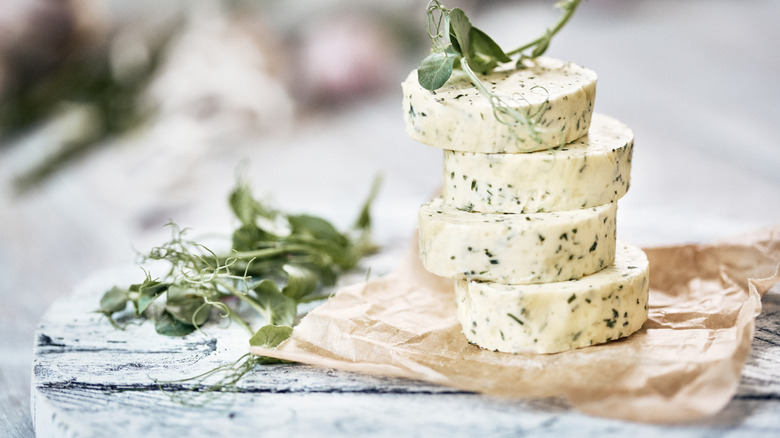 Stack of slabs of compound butter with herbs