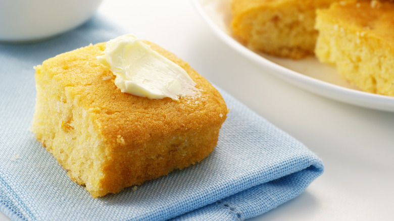 square of buttered corn cake on blue napkin