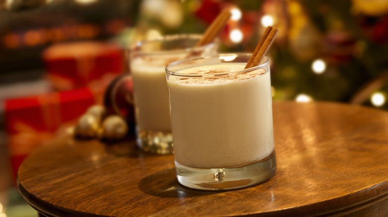 Two glasses of eggnog with cinnamon sticks