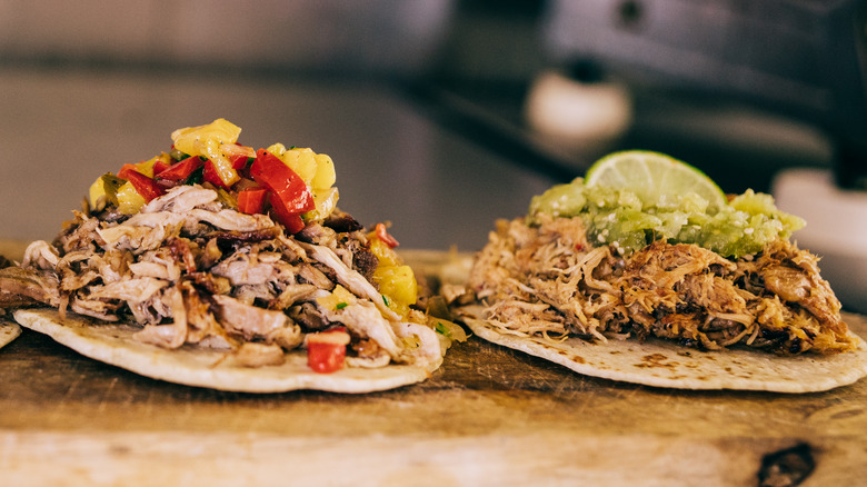 Two tacos on a cutting board