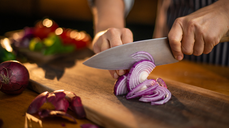 person cutting red onions