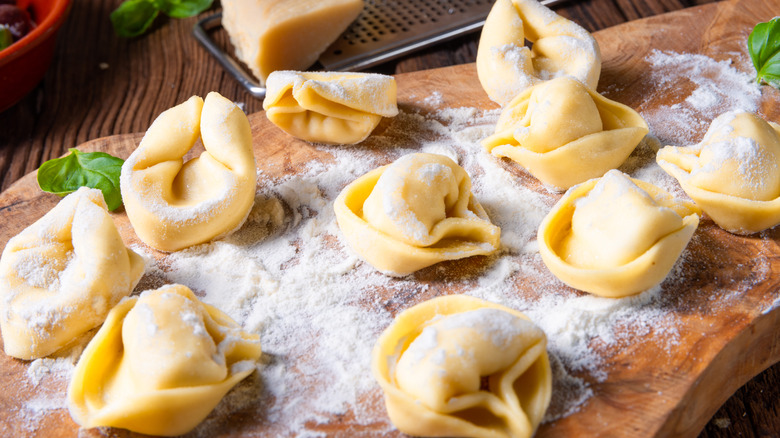 Fresh tortellini on wooden board