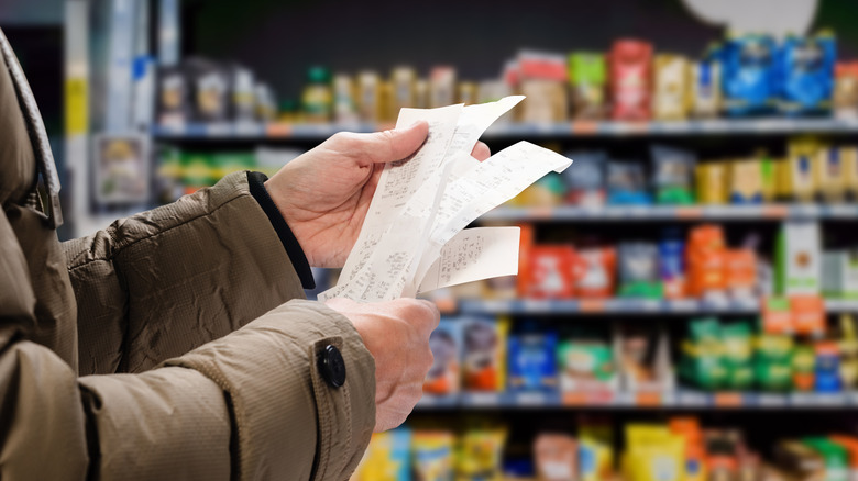 shopper holding grocery receipts