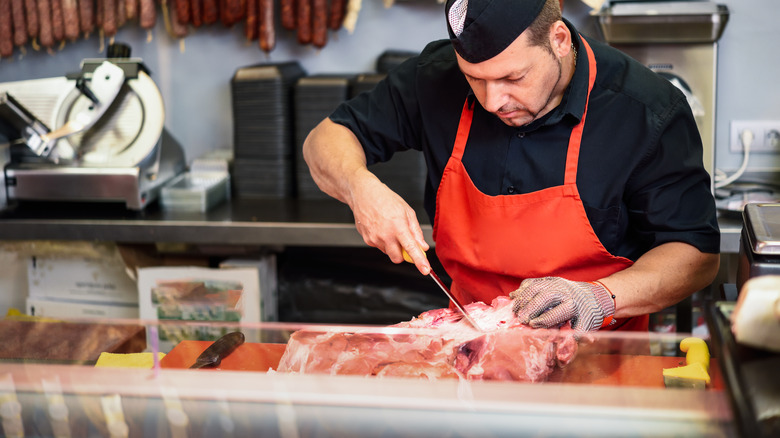 butcher trimming meat