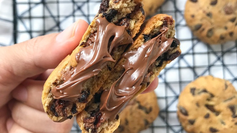 hand holding Nutella stuffed chocolate chip cookie