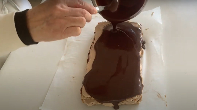 Making marjolaine cake and spreading melted chocolate