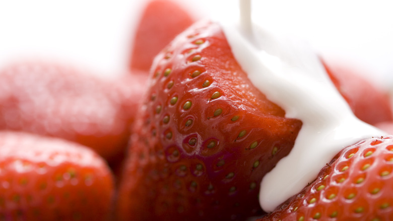 Pouring cream on strawberries