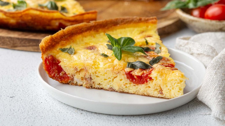 slice of frittata with tomatoes, prosciutto, and basil