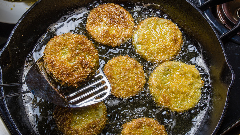 Frying green tomatoes in a skillet with oil