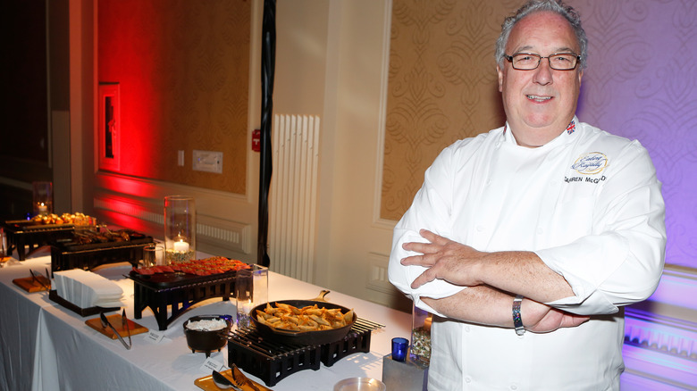 Darren McGrady posing beside buffet