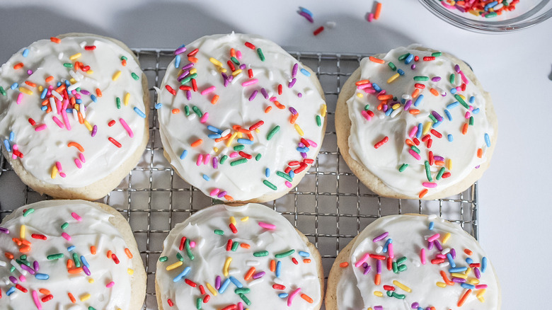 frosted sugar cookies on baking sheet 