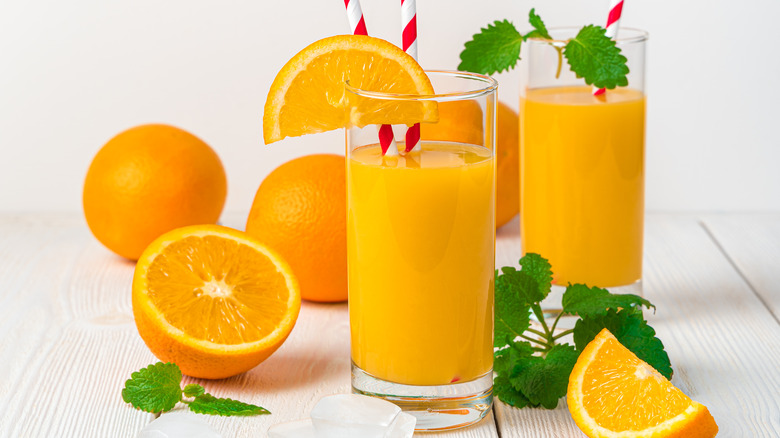 orange juice glasses and oranges