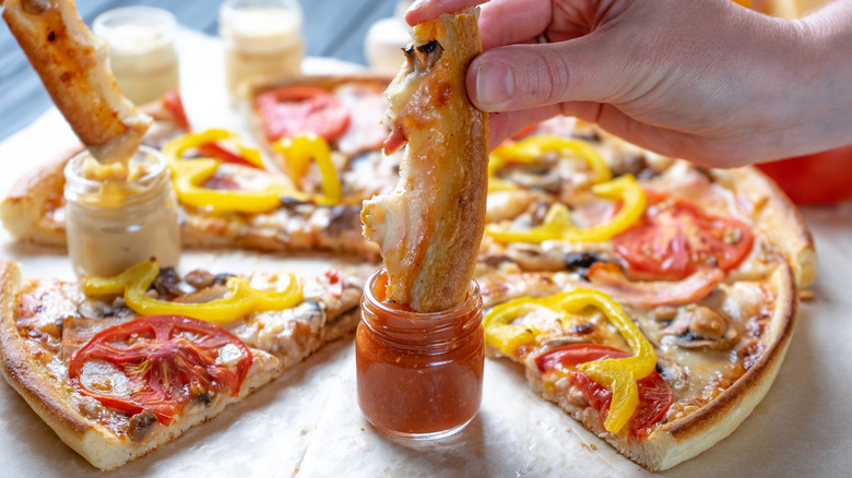 Pizza crust dipped in sauce