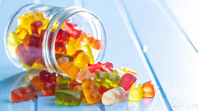 Glass jar on its side with gummy bears spilling out