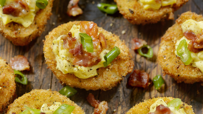 Fried hard boiled eggs with mayo, bacon bits and scallions