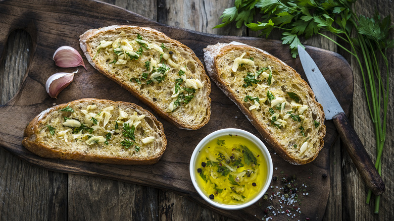 Garlic bread with herbs on a cutting board