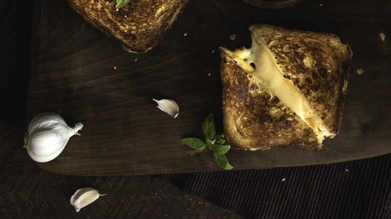 grilled cheese next to garlic cloves and basil