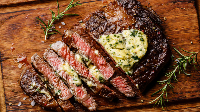 sliced steak with herb butter on top