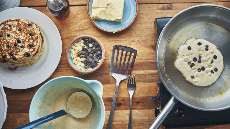 Preparation of blueberry pancakes with batter and chocolate chips