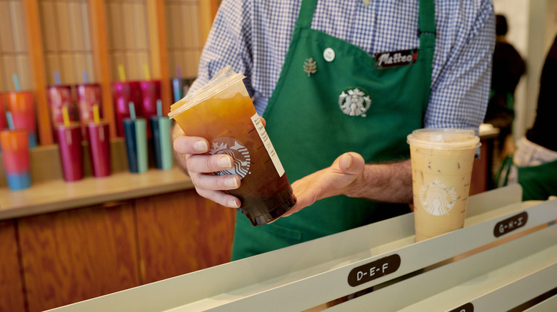 Starbucks employee with iced drink