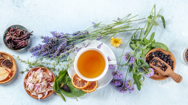 Tea pot surrounded by herbs