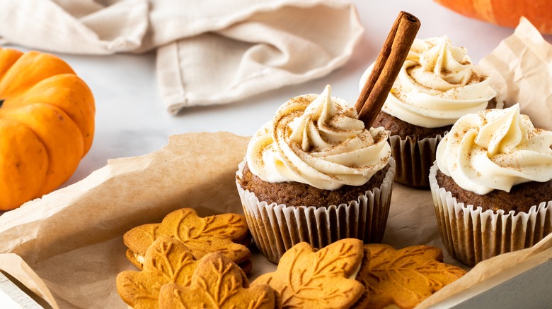 Pumpkin cupcakes and maple cookies on a baking sheet