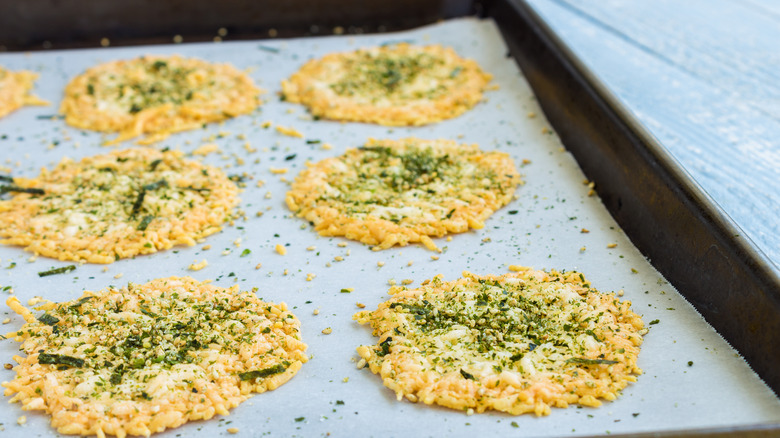 Seasoned parmesan crisps on parchment lined sheet pan