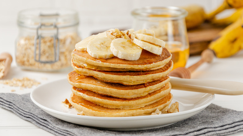 stack of pancakes topped with banana