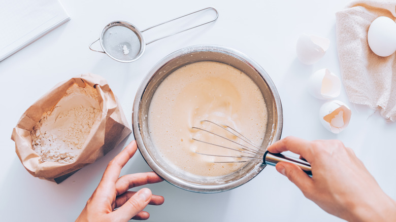 whisking pancake batter in mixing bowl