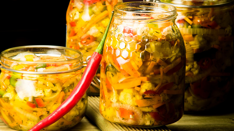 Jars of giardiniera with a chili pepper in front