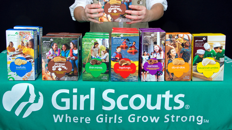 Girl Scout behind cookie table