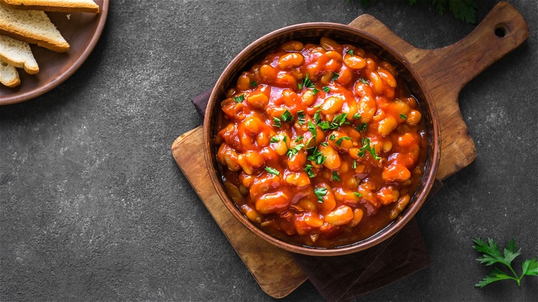 Baked beans in bowl with herbs 