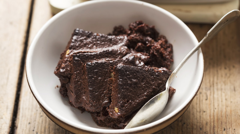 Chocolate bread pudding in a bowl on wood surface